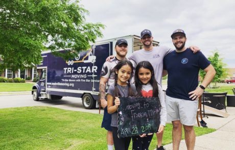 Tri Star Moving team with a happy family
